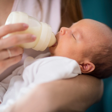 Bébé qui boit au biberon - Laboratoires Gilbert