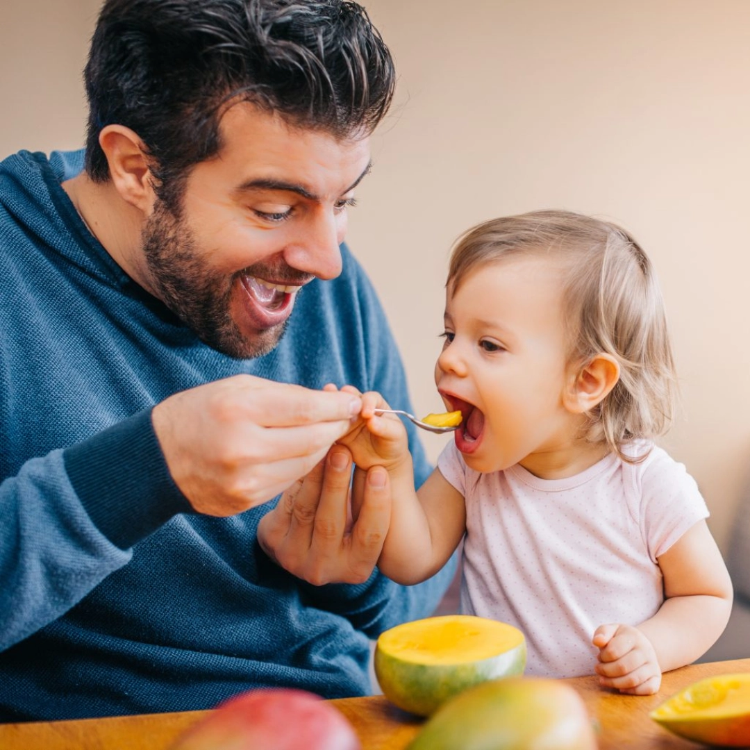 Papa qui fait manger du melon a sa fille - Laboratoires Gilbert