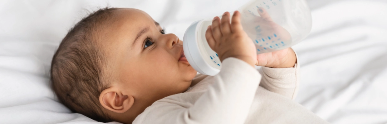 Bébé tenant un biberon – Laboratoires Gilbert